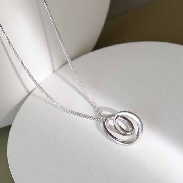Amara Jewels abstract pendant necklace in sterling silver with intertwined loops design.