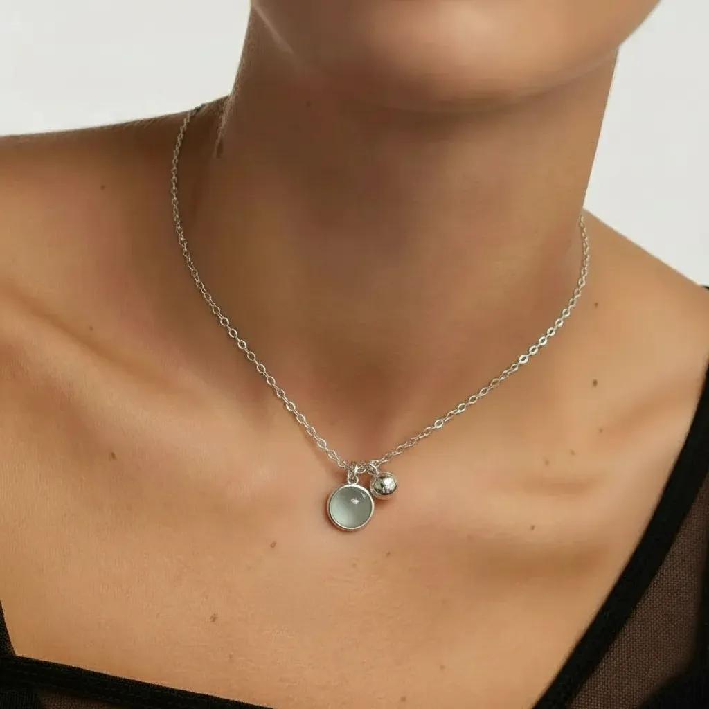 Amara Jewels sterling silver necklace with a round aqua charm and a polished silver bead.