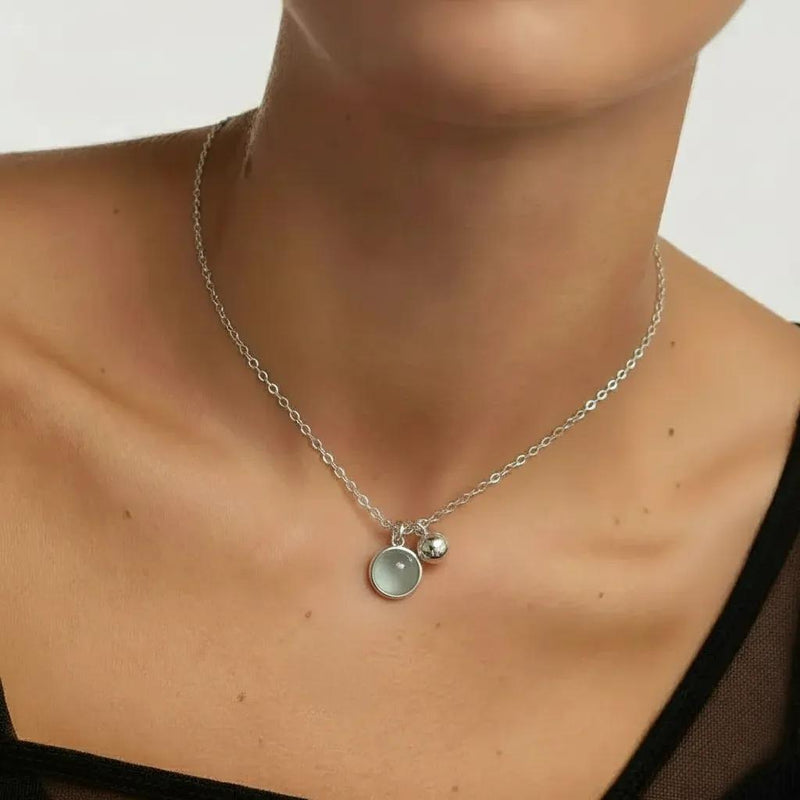 Amara Jewels sterling silver necklace with a round aqua charm and a polished silver bead.