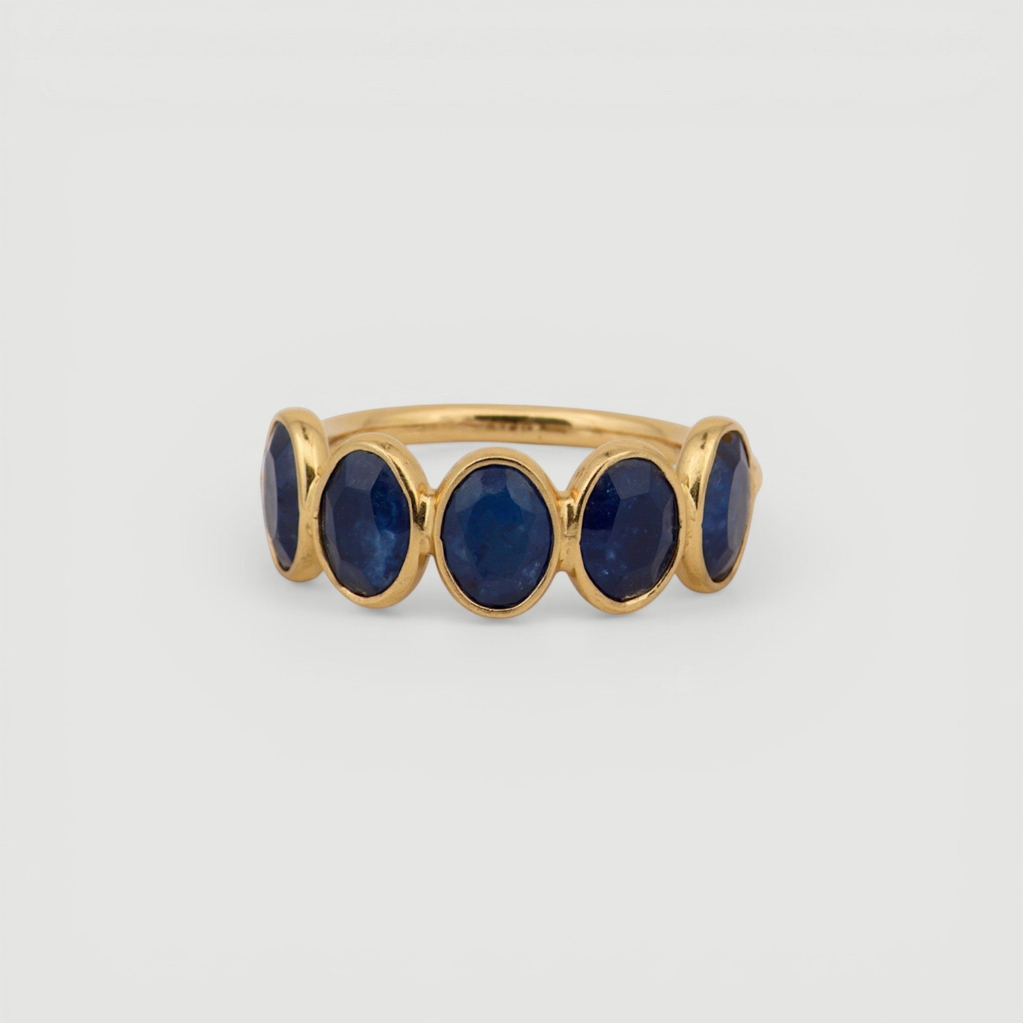 Amara Jewels gold-plated sterling silver band ring with five oval-cut blue sapphire gemstones.