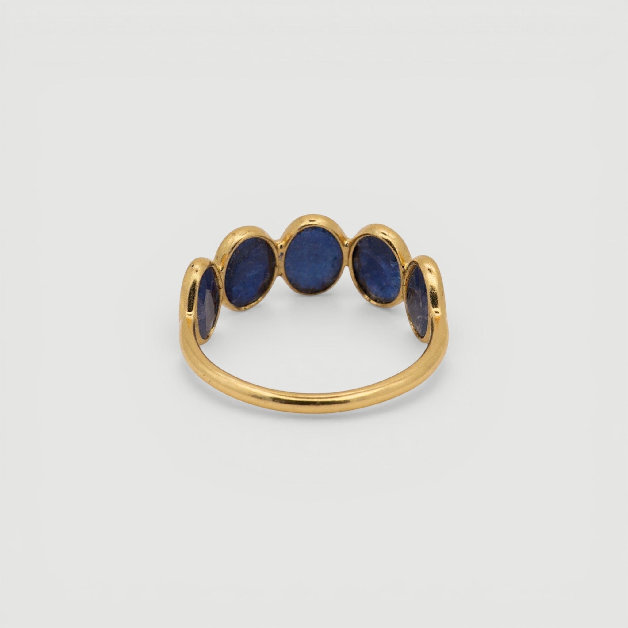 Amara Jewels gold-plated sterling silver band ring with five oval-cut blue sapphire gemstones.