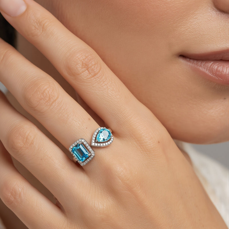Amara Jewels open ring with emerald-cut and pear-shaped blue topaz stones, accented with cubic zirconia, set in sterling silver.