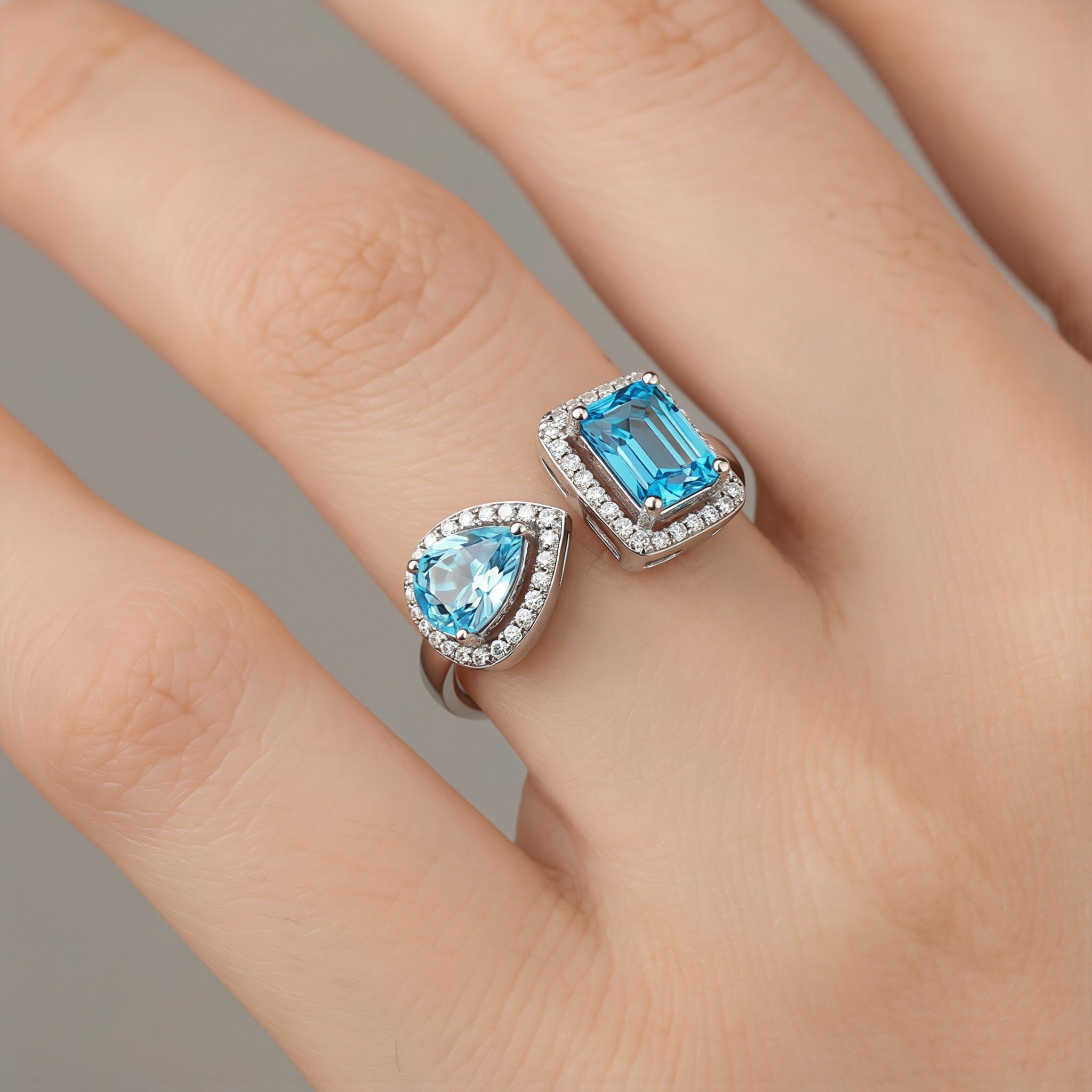 Amara Jewels open ring with emerald-cut and pear-shaped blue topaz stones, accented with cubic zirconia, set in sterling silver.