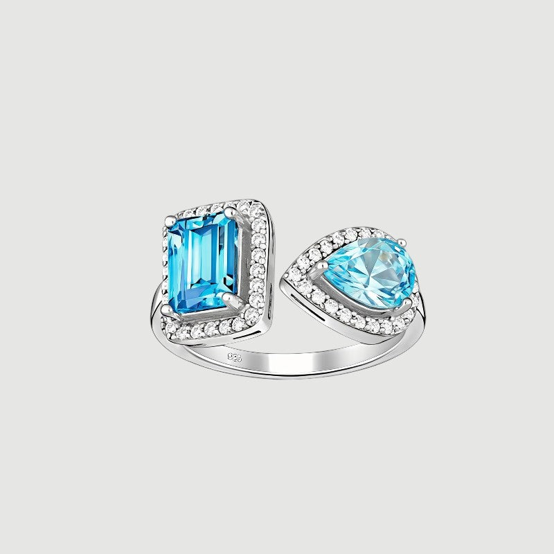 Amara Jewels open ring with emerald-cut and pear-shaped blue topaz stones, accented with cubic zirconia, set in sterling silver.