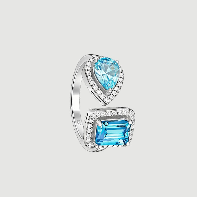 Amara Jewels open ring with emerald-cut and pear-shaped blue topaz stones, accented with cubic zirconia, set in sterling silver.