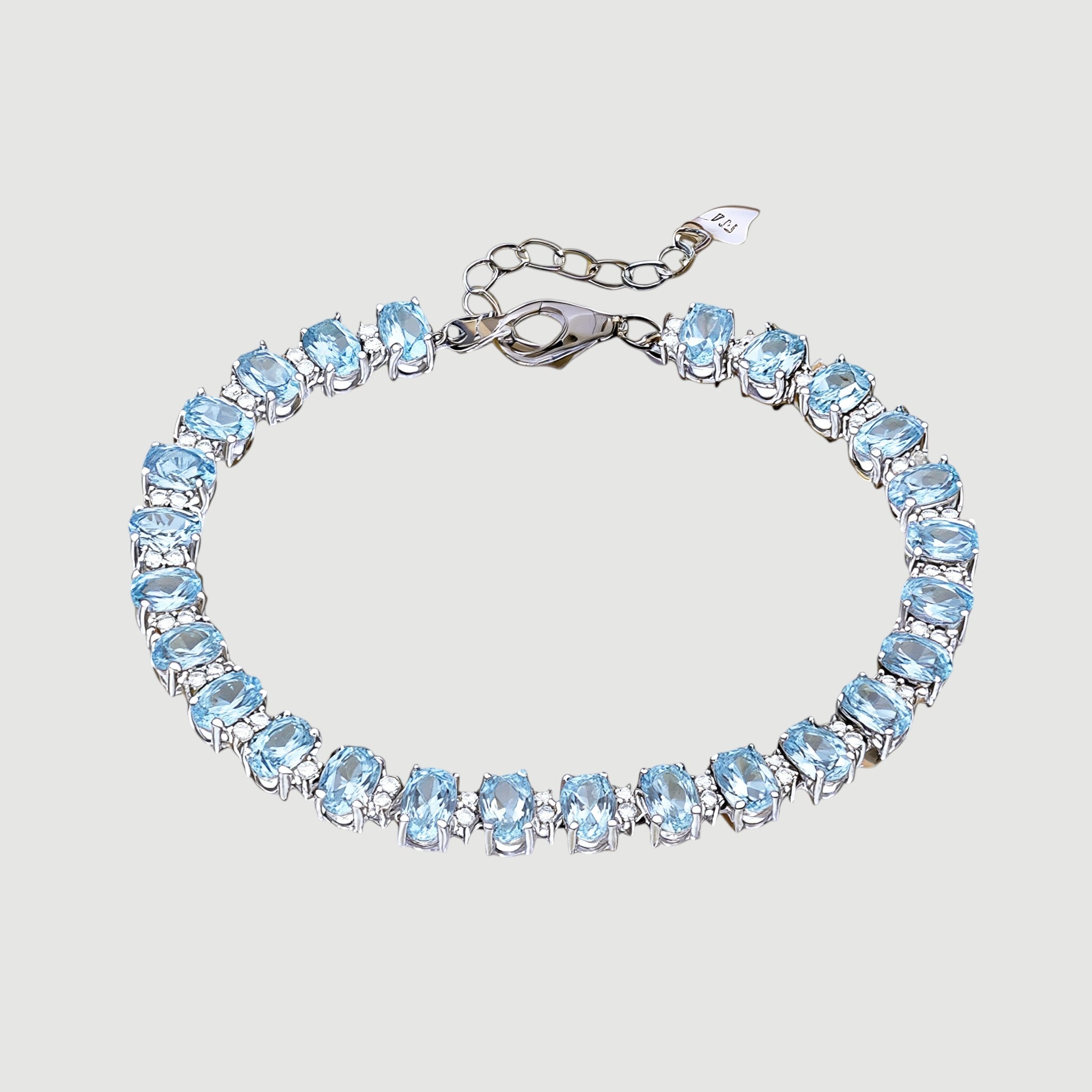 Amara Jewels blue topaz tennis bracelet in 925 sterling silver with adjustable clasp. Oval cut stones.