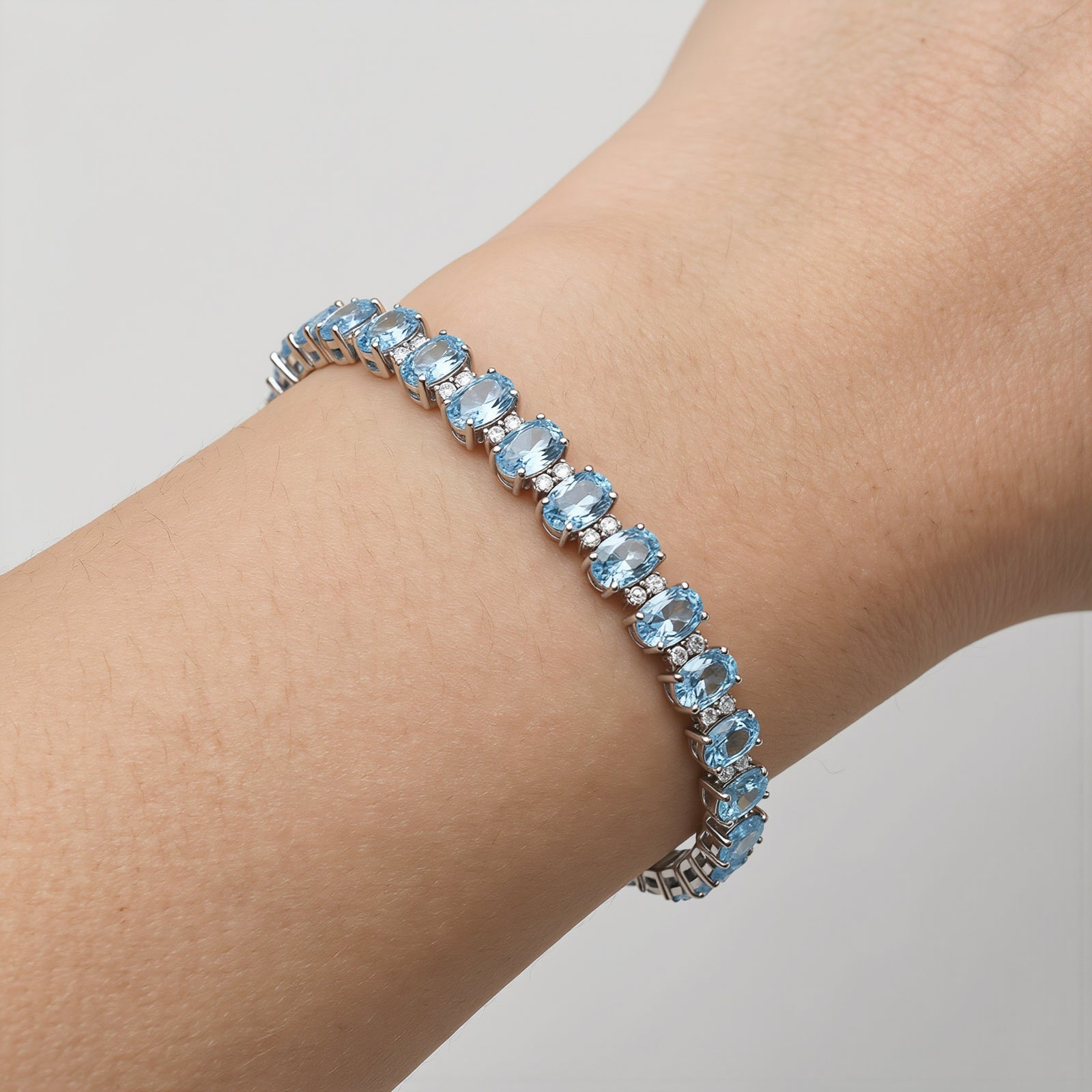 Amara Jewels blue topaz tennis bracelet in 925 sterling silver with adjustable clasp. Oval cut stones.