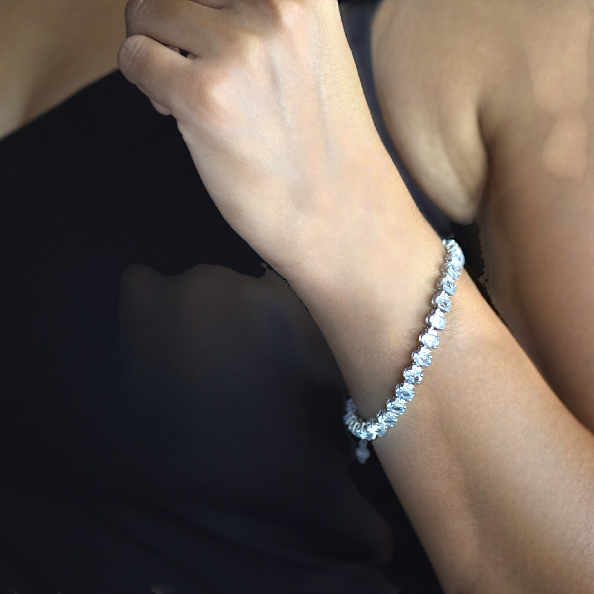 Amara Jewels blue topaz tennis bracelet in 925 sterling silver with adjustable clasp. Oval cut stones.