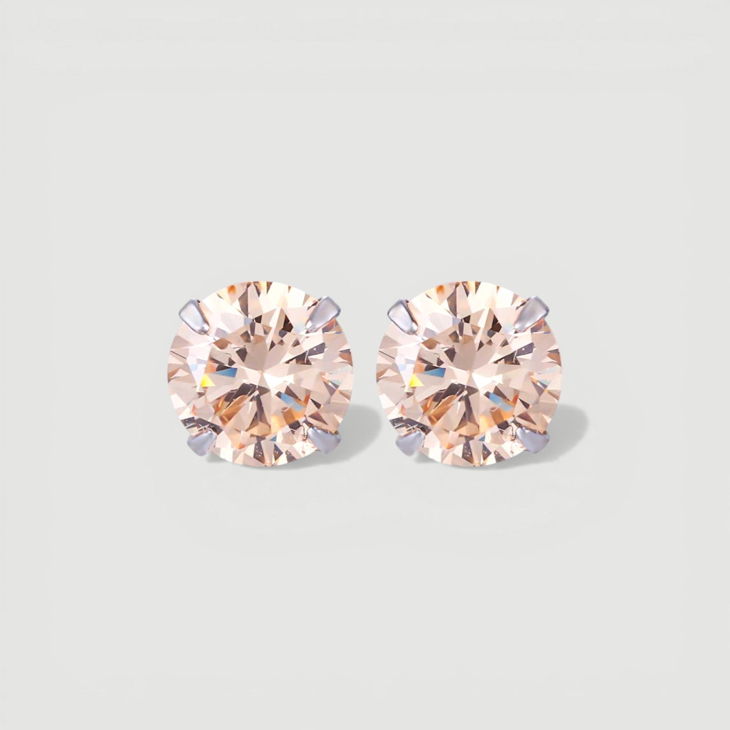 Amara Jewels champagne cubic zirconia stud earrings with round-cut stones in a four-prong setting.