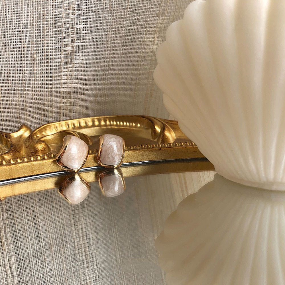 Amara Jewels champagne pearl stud earrings with textured gold plating and half-moon shape.