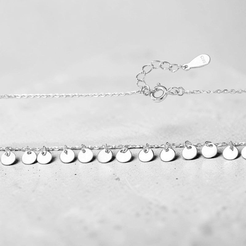 Amara Jewels delicate sterling silver necklace with multiple small disc charms, perfect for everyday wear.