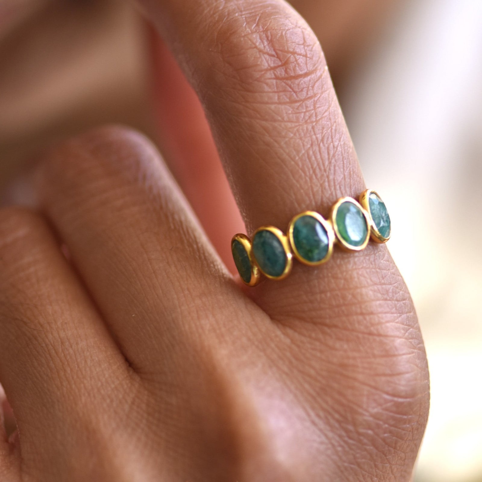 Amara Jewels 18K gold vermeil ring with five oval-cut emeralds set in sterling silver.