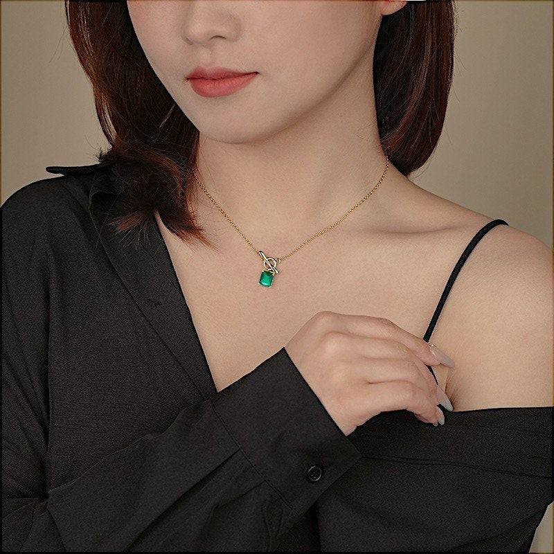 Amara Jewels gold vermeil sterling silver necklace with a rectangular emerald-green gemstone and toggle clasp.