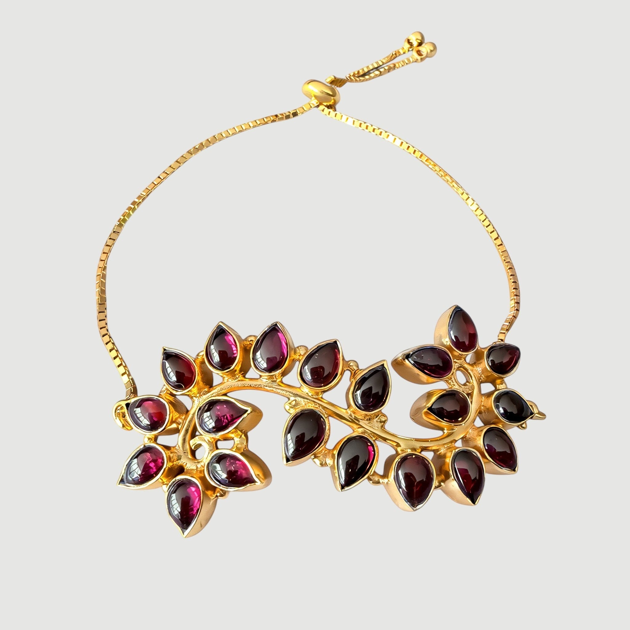 Amara Jewels Radiant Bloom Garnet Bracelet with pear-cut garnet stones in a floral vine design, 925 sterling silver with gold vermeil finish.