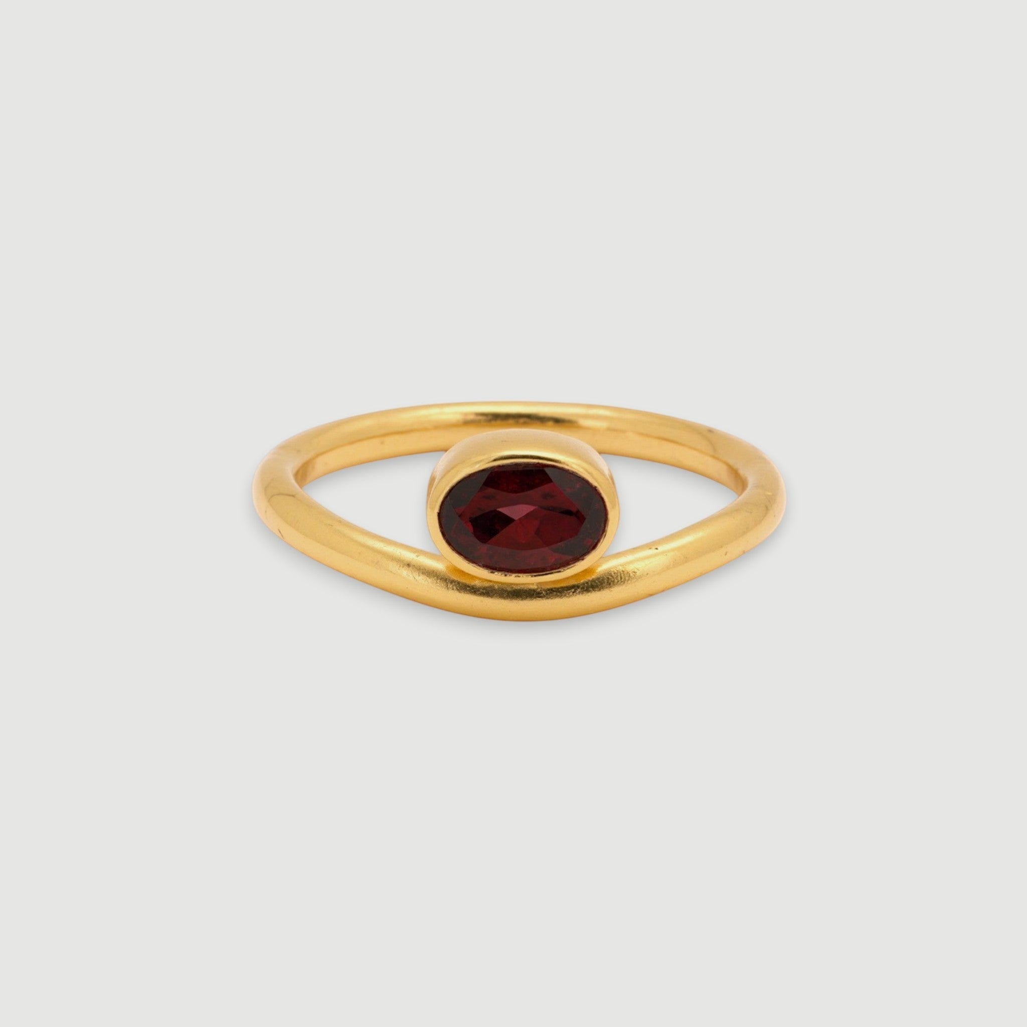 Amara Jewels 18K gold vermeil sterling silver ring with a bezel-set oval garnet gemstone. Minimalist design.