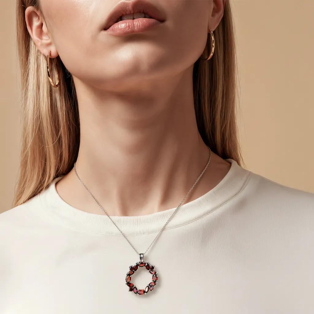 Amara Jewels sterling silver necklace with a wreath pendant featuring deep red natural garnet gemstones.