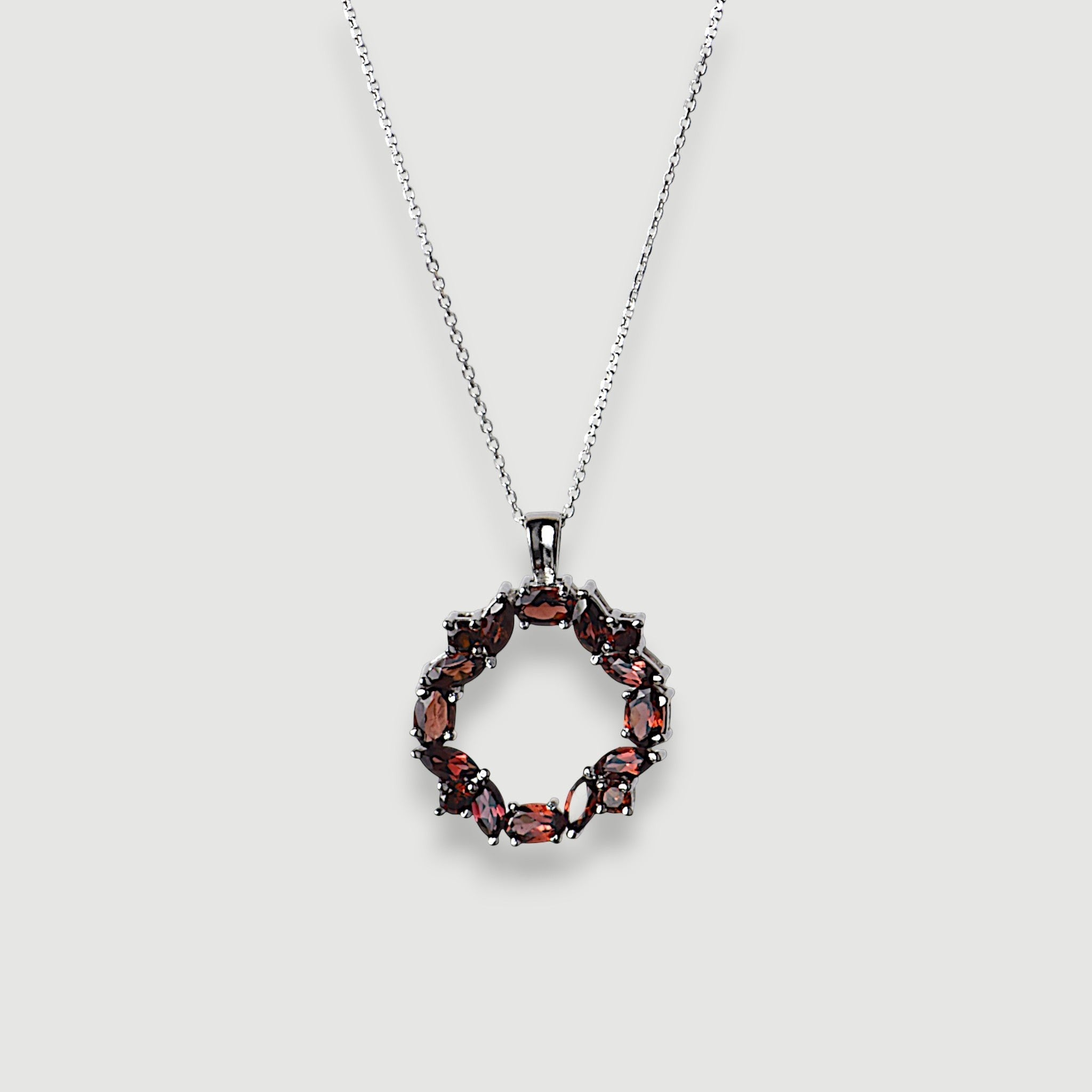 Amara Jewels sterling silver necklace with a wreath pendant featuring deep red natural garnet gemstones.