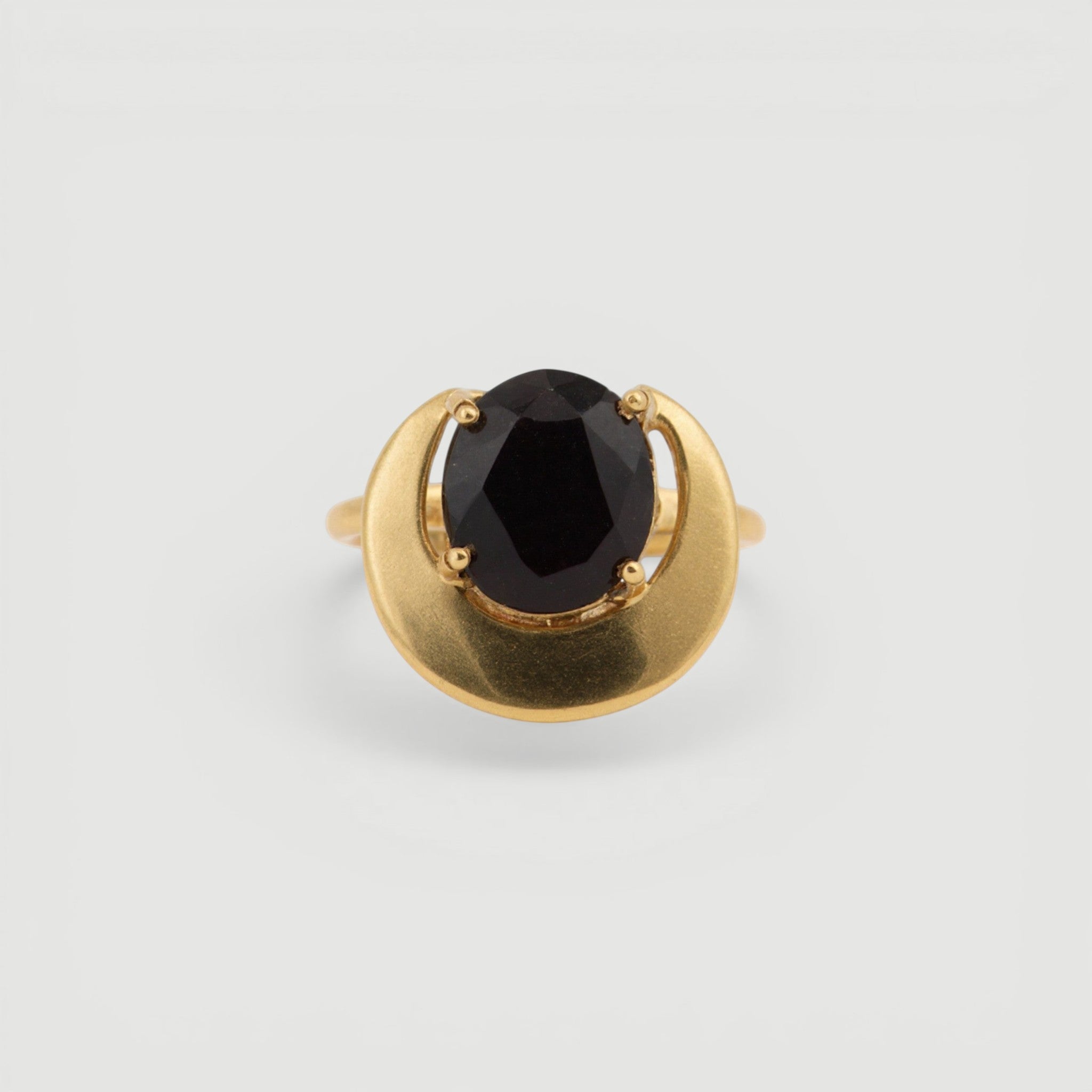 Amara Jewels gold ring with a dark grey gemstone in a crescent bezel on a 925 sterling silver band with 18k gold vermeil.