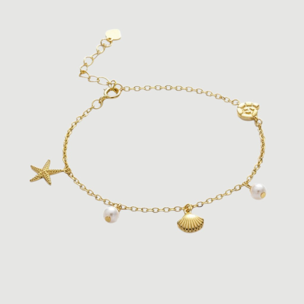 Amara Jewels gold-plated sterling silver bracelet with starfish, shell, pearl charms and adjustable clasp.