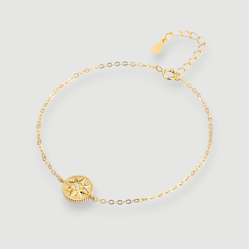Amara Jewels gold-plated sterling silver bracelet with a celestial compass charm adorned with cubic zirconia. Adjustable chain.