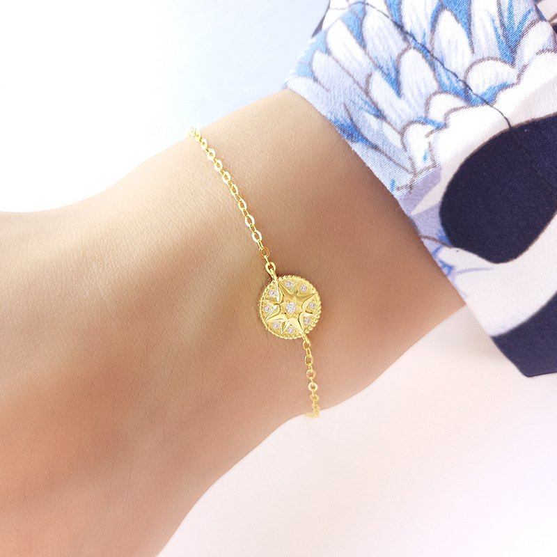 Amara Jewels gold-plated sterling silver bracelet with a celestial compass charm adorned with cubic zirconia. Adjustable chain.