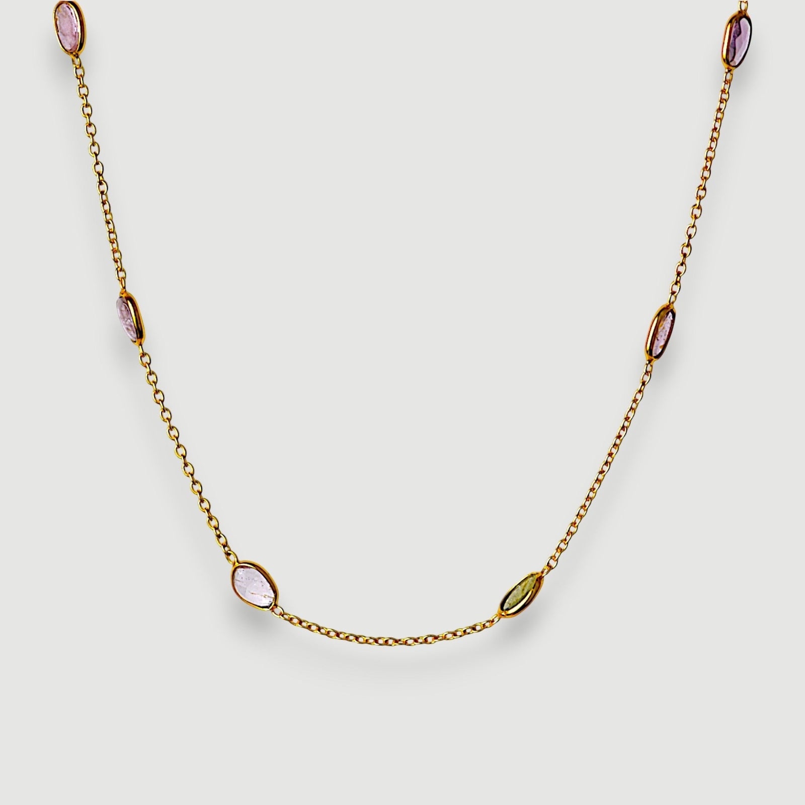 Amara Jewels 18K gold vermeil station necklace with bezel-set pastel amethyst, rose quartz, and green tourmaline.
