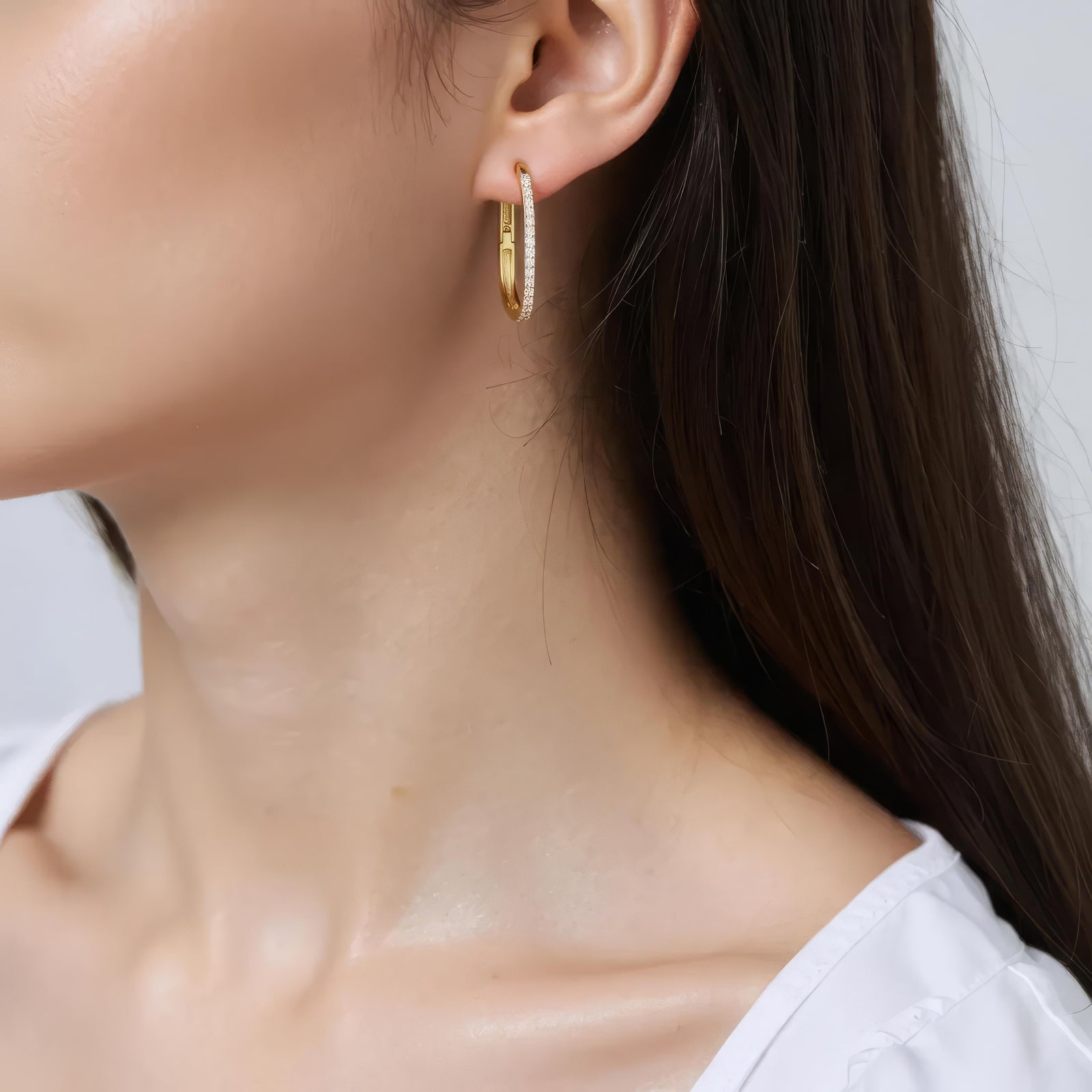 Amara Jewels gold-plated sterling silver oval hoop earrings with cubic zirconia accents.