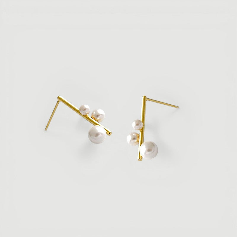 Amara Jewels gold-plated sterling silver earrings with three pearls on a geometric bar design.