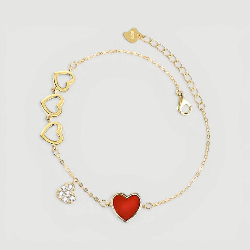 Amara Jewels gold-finished sterling silver bracelet with red enamel heart, cubic zirconia charm, and open hearts.
