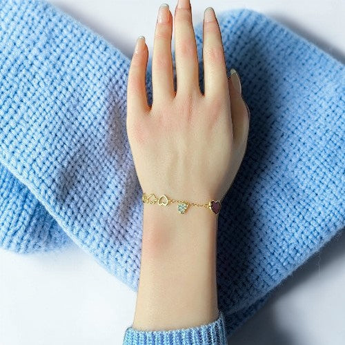 Amara Jewels gold-finished sterling silver bracelet with red enamel heart, cubic zirconia charm, and open hearts.