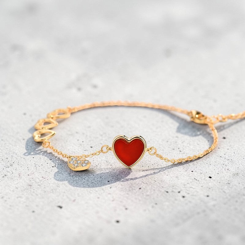 Amara Jewels gold-finished sterling silver bracelet with red enamel heart, cubic zirconia charm, and open hearts.