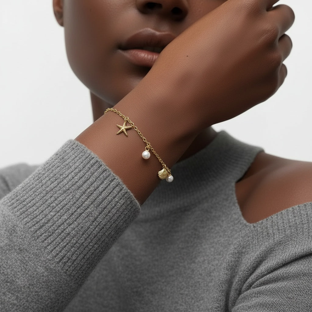 Amara Jewels gold-plated sterling silver bracelet with starfish, shell, pearl charms. Adjustable chain.
