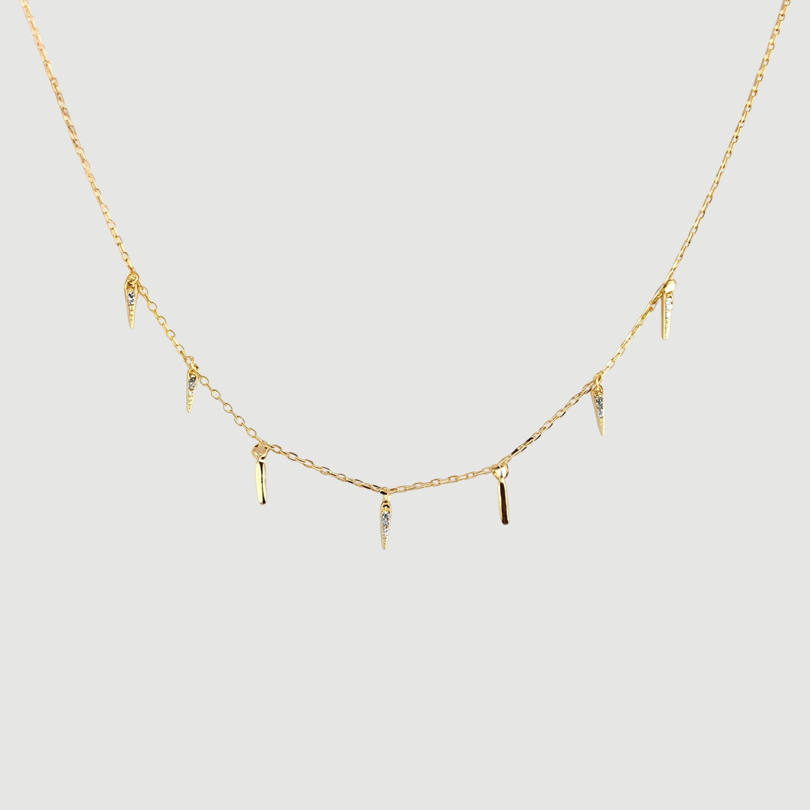 Amara Jewels gold-plated sterling silver necklace with dangling spike charms and small crystals.