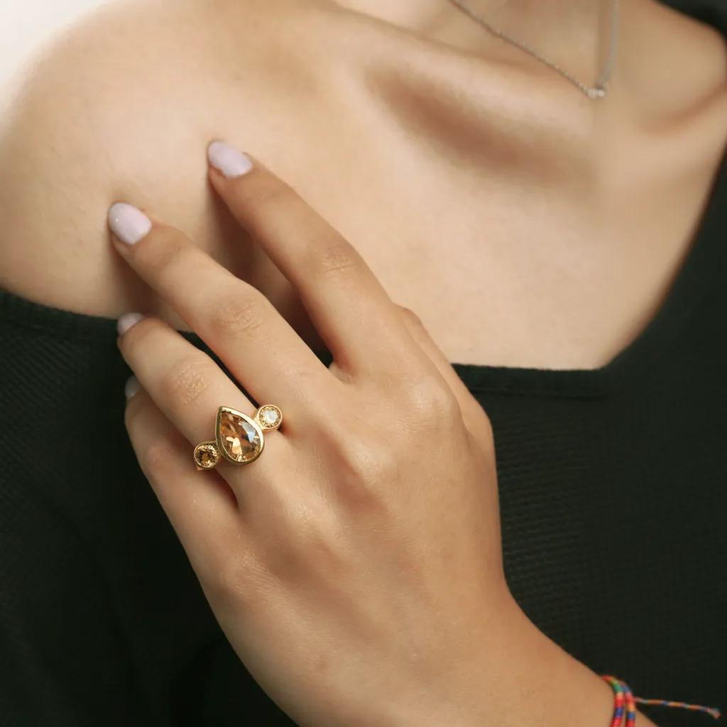Amara Jewels elegant golden topaz ring with pear-shaped center stone and accent stones, 18K gold vermeil over 925 sterling silver.