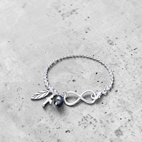 Amara Jewels sterling silver bracelet with infinity symbol, leaf charm, cross charm, and black pearl.