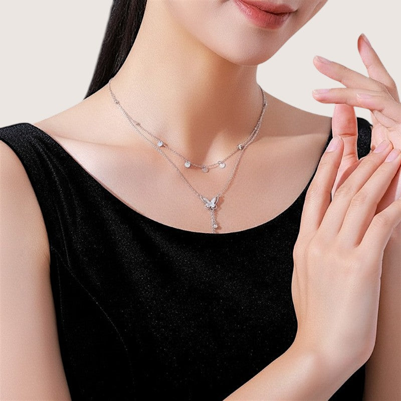 Amara Jewels double-layered sterling silver necklace with butterfly pendant and dangling crystals.