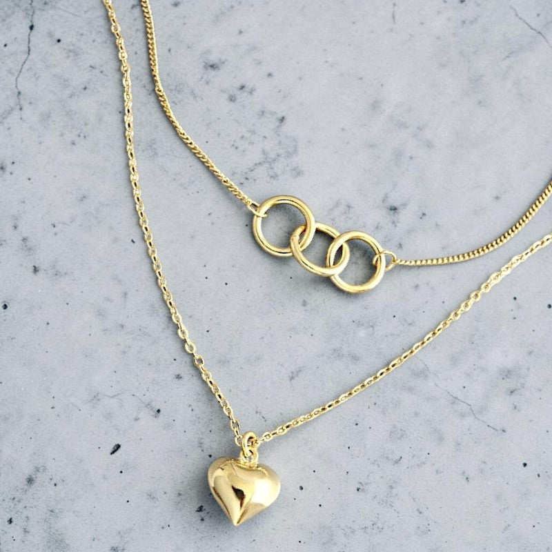 Amara Jewels gold-plated sterling silver layered necklace with heart and interlocking circles pendants.