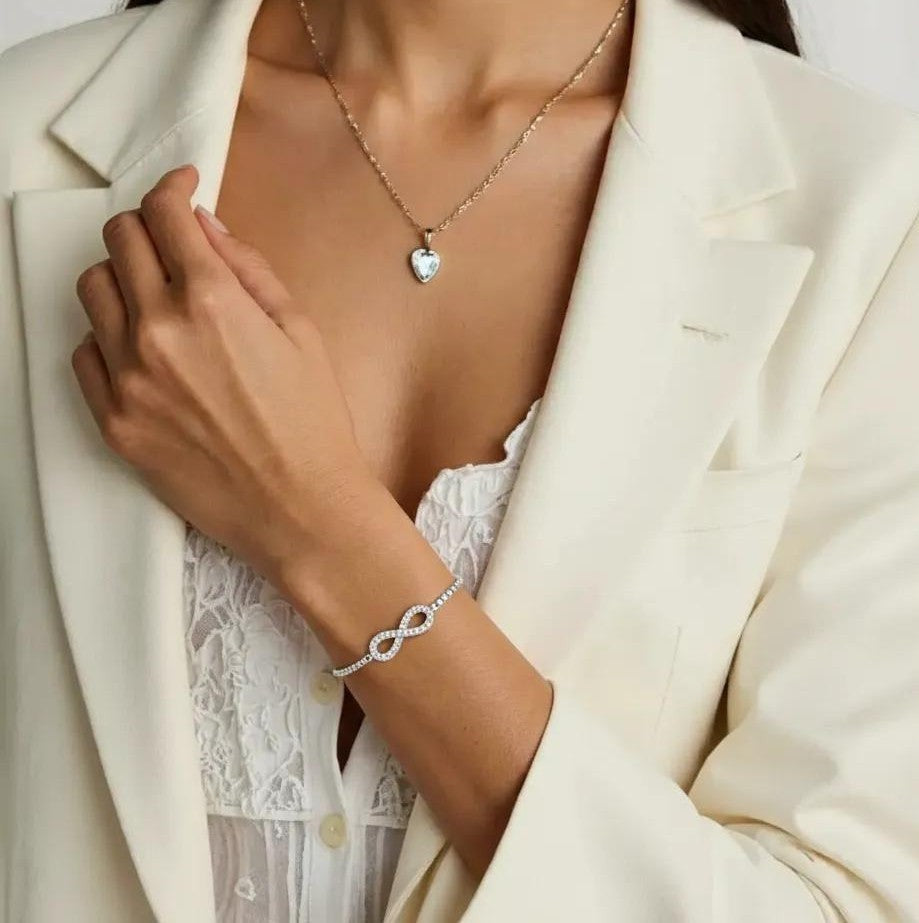 Amara Jewels sterling silver bracelet with infinity symbol adorned with stones, adjustable slider clasp.