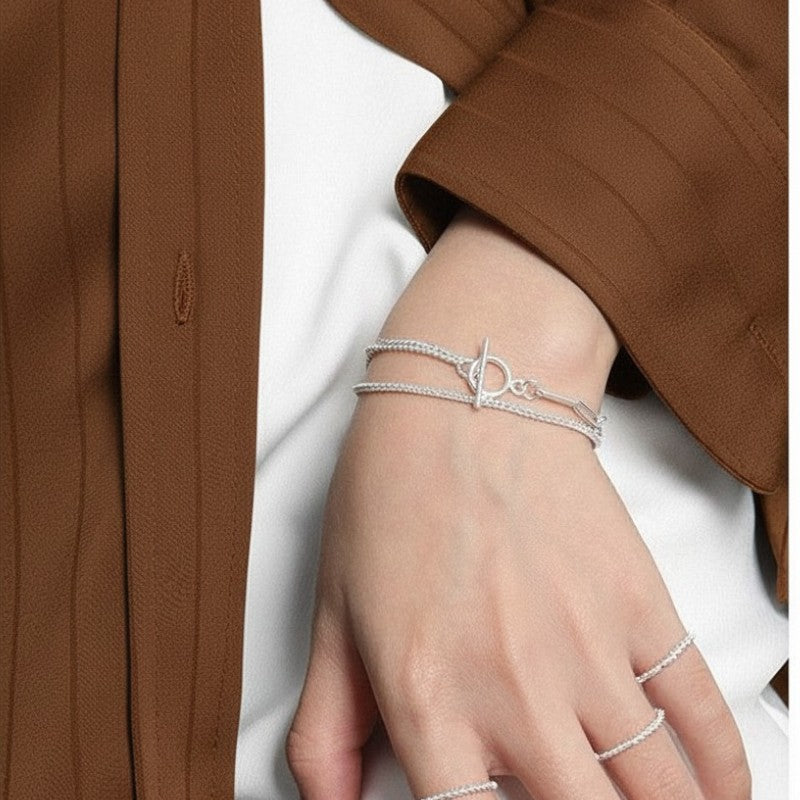 Amara Jewels layered chain sterling silver bracelet with toggle clasp featuring circle T charm.