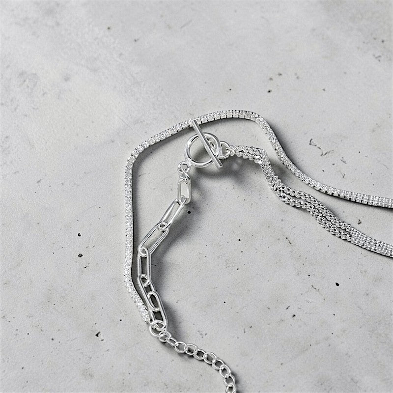 Amara Jewels layered chain sterling silver bracelet with toggle clasp featuring circle T charm.