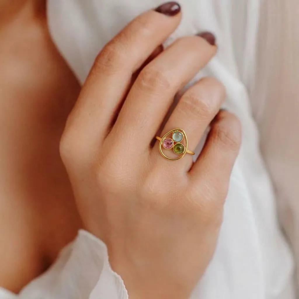 Amara Jewels gold vermeil ring with bezel-set pink, green, and black tourmaline gemstones in a sculptural open frame.