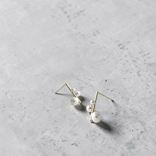 Amara Jewels modern gold-plated sterling silver earrings with three white pearls of varying sizes.