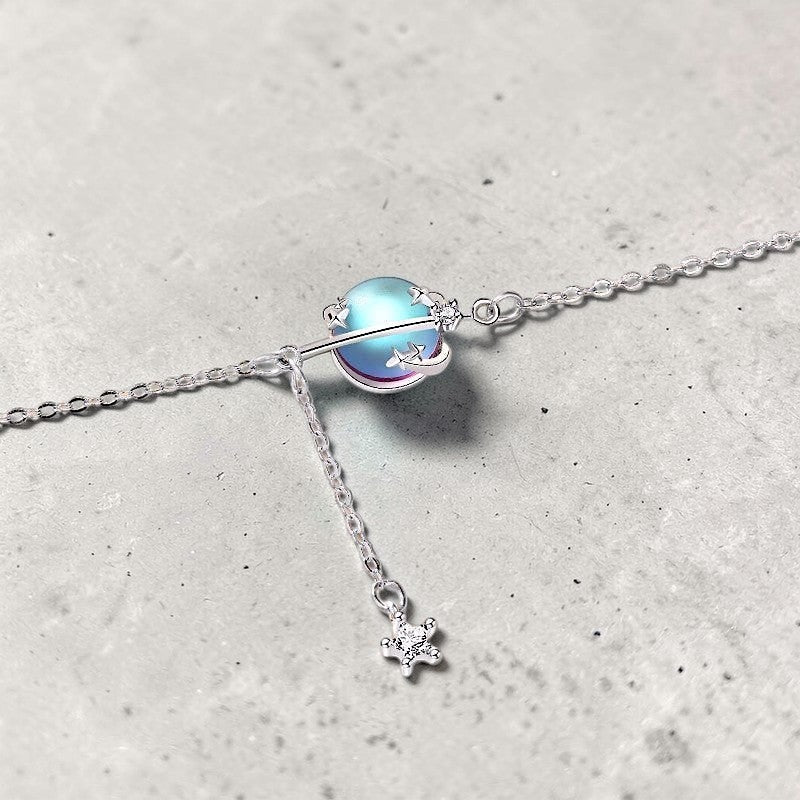 Amara Jewels 925 sterling silver adjustable bracelet with iridescent blue planet charm and dangling star.