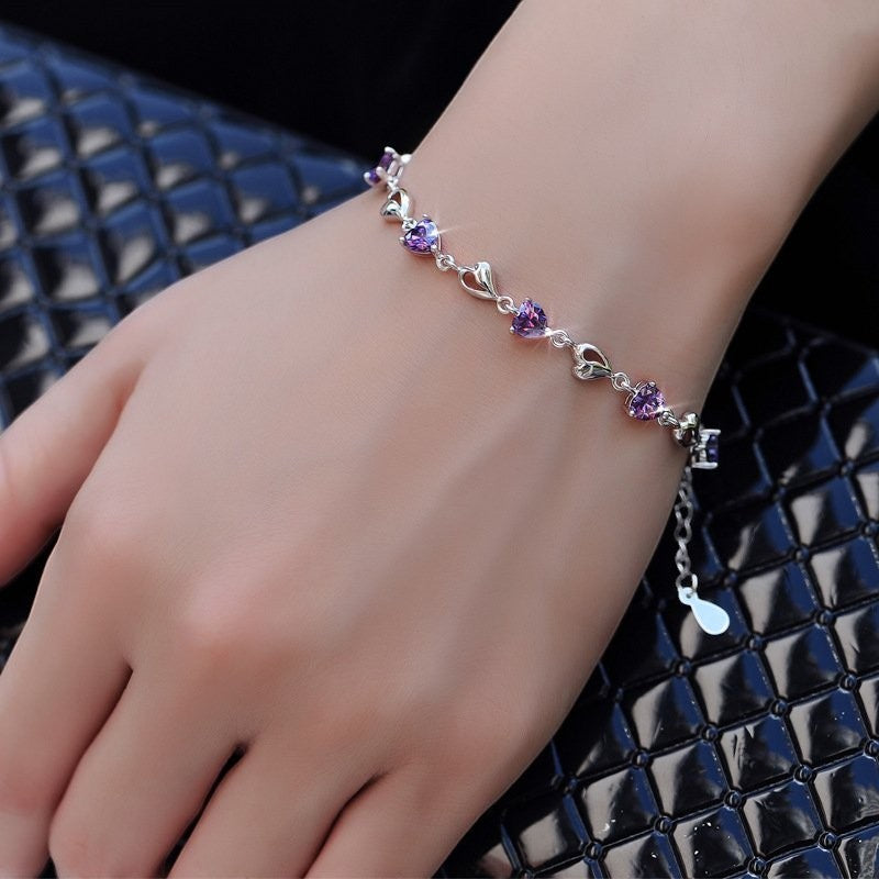 Amara Jewels sterling silver bracelet with purple heart-shaped links and shimmering stones.