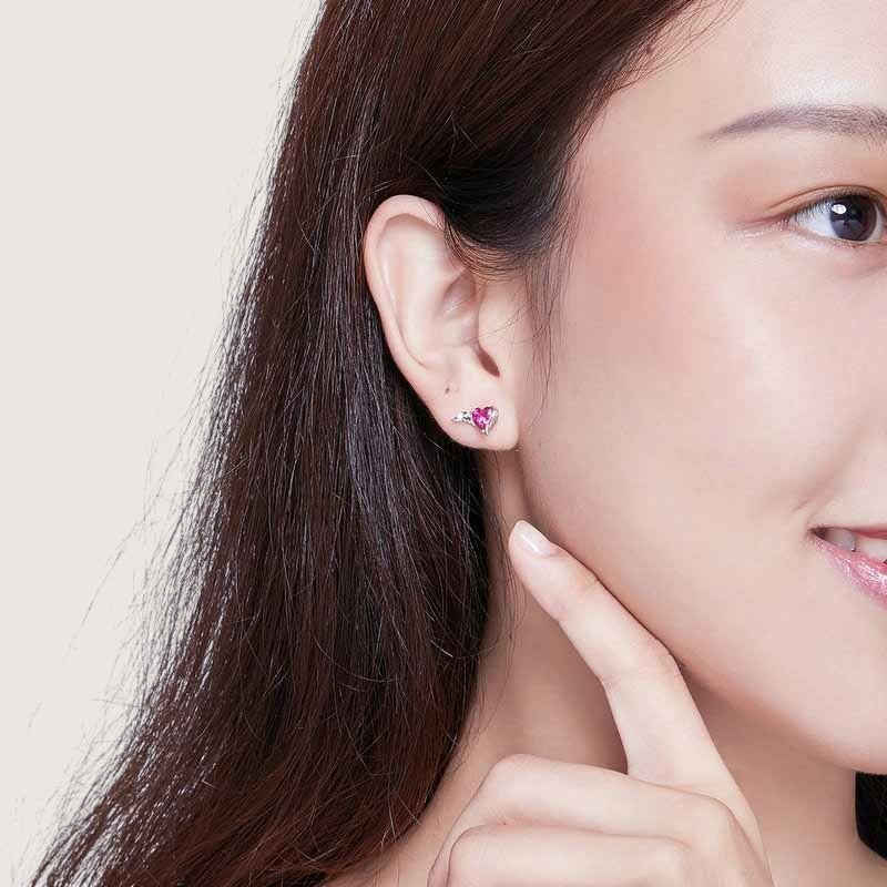 Amara Jewels sterling silver stud earrings with red heart-shaped gemstones and angel wings.