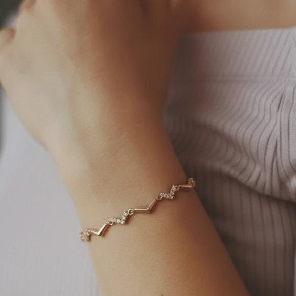 Amara Jewels rose gold chevron bracelet with zircon accents, delicate chain, minimalist design.