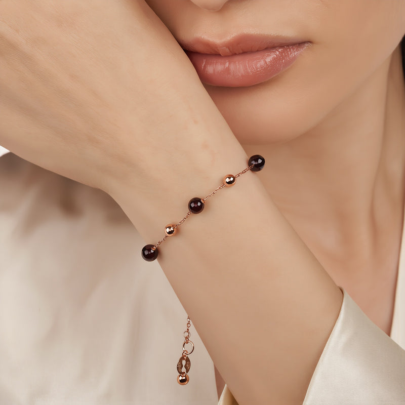 Amara Jewels rose gold plated sterling silver bracelet with garnet beads and rose gold accent beads.