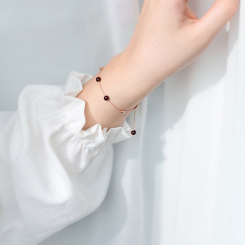 Amara Jewels rose gold plated sterling silver bracelet with garnet beads and rose gold accent beads.