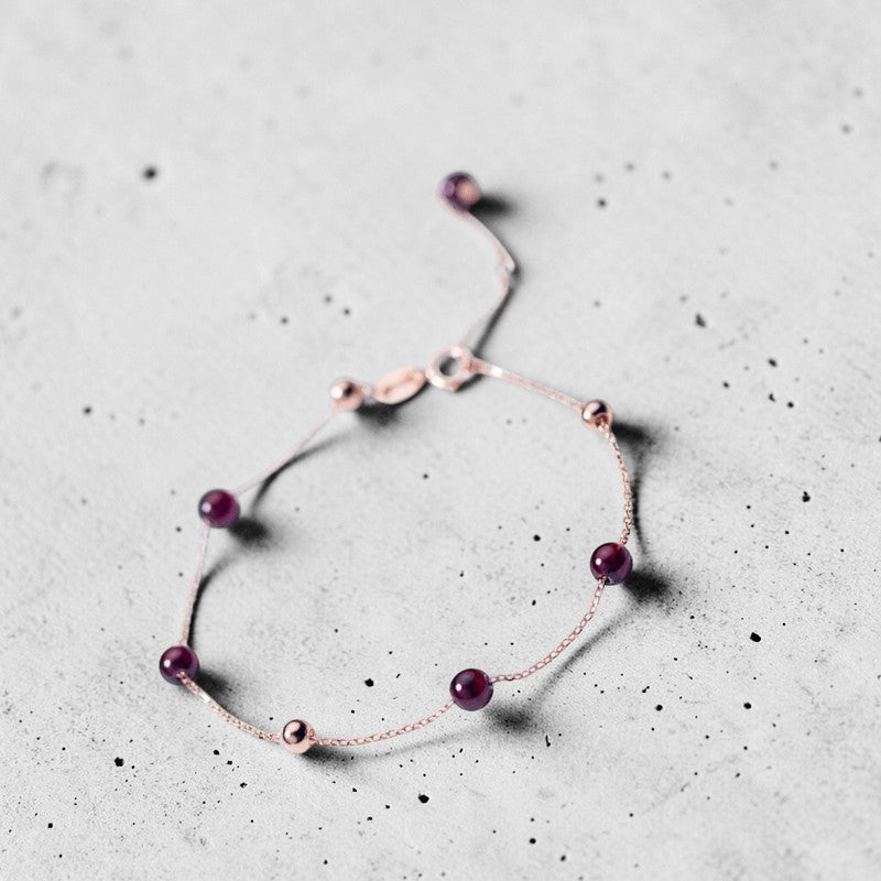 Amara Jewels rose gold plated sterling silver bracelet with garnet beads and rose gold accent beads.