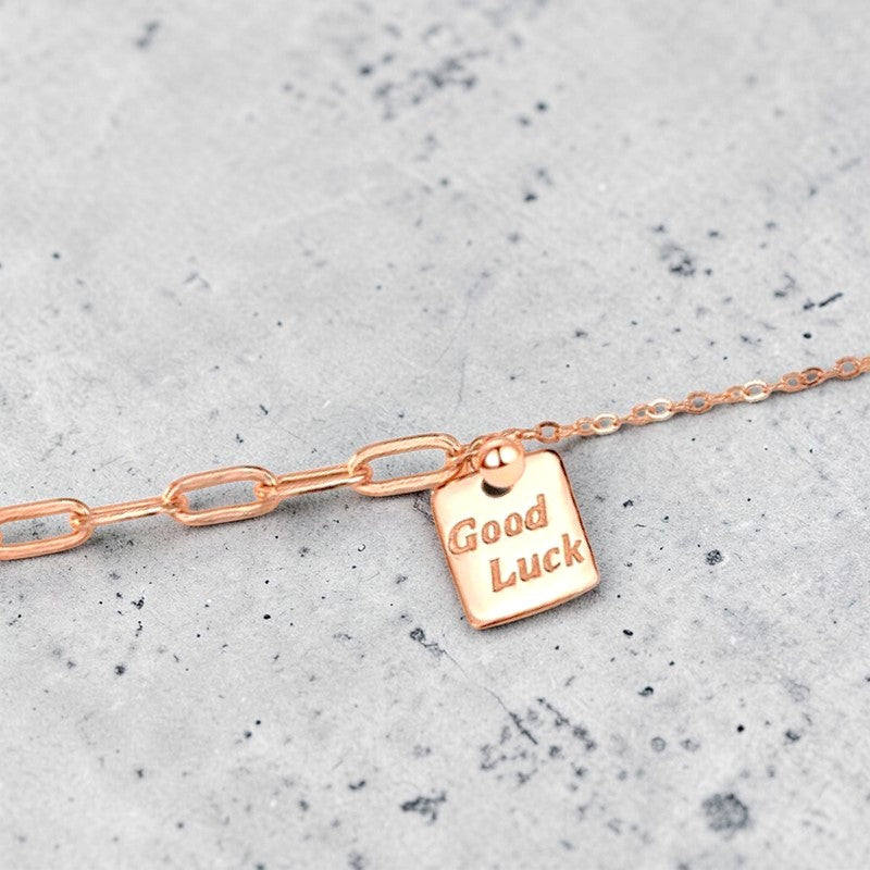 Amara Jewels rose gold plated sterling silver bracelet with a square 'Good Luck' charm and mixed chain links.